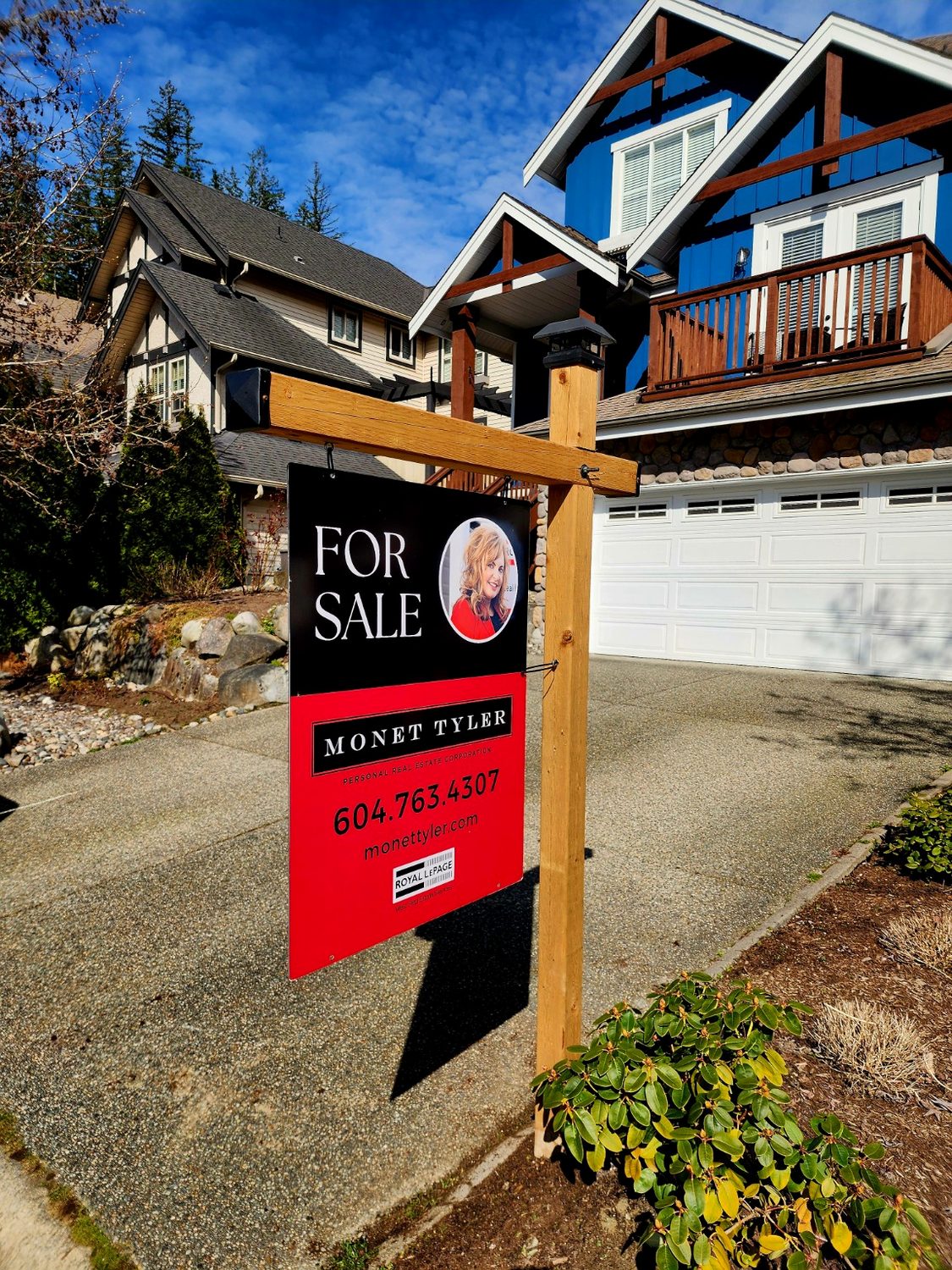 Natural wood sign post at residential listing